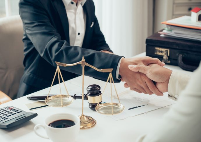 Businessman shaking hands to seal a deal with his partner lawyers or attorneys discussing a contract agreement